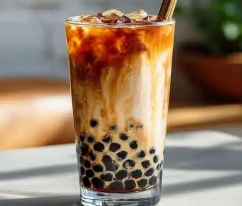 Colorful bubble tea drinks with various toppings in a trendy café setting.