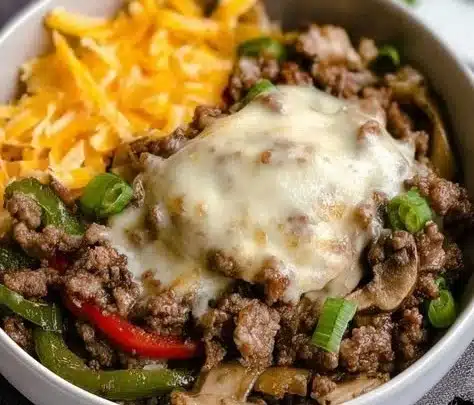 Delicious Philly Cheesesteak Bowl topped with melting cheese and peppers.