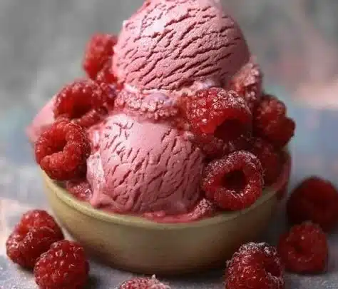 Creamy Raspberry Ice Cream topped with fresh raspberries and mint leaves