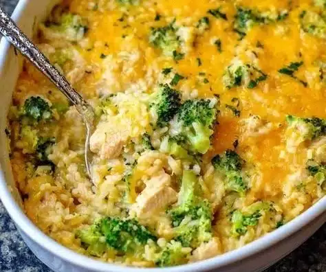 Cheesy chicken broccoli casserole with rice, fresh broccoli, and melted cheese