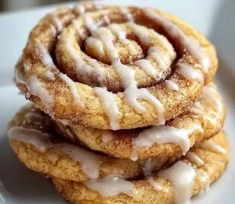 Cinnamon Roll Cookies 8 Delicious cinnamon roll cookies topped with icing on a plate