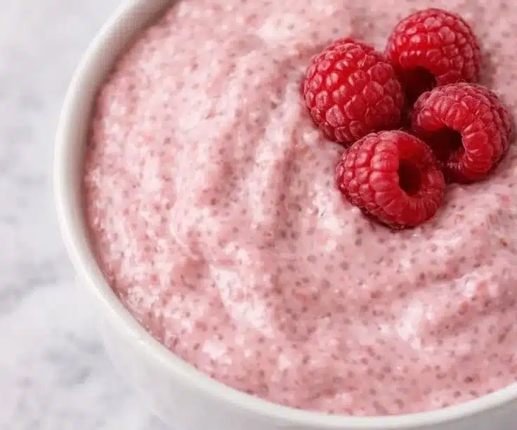 Bowl of delicious raspberry chia seed pudding topped with fresh raspberries
