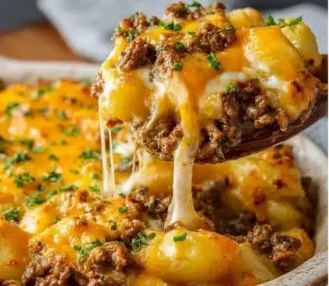 Ground beef and potatoes casserole topped with cheese and herbs