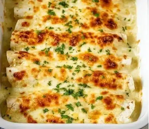 Delicious white chicken enchiladas topped with creamy sauce and cheese